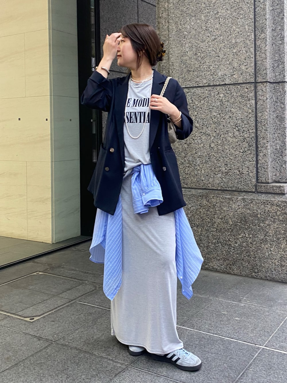 ブルー系のテーラードジャケット、グレー系のTシャツ/カットソー、グレー系のスカートを着用したレディースの春コーディネートの5枚目の写真
