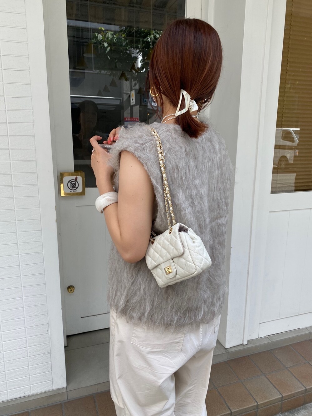 ベージュ系のベスト、ベージュ系のその他パンツ、ホワイト系のタンクトップを着用したレディースの秋コーディネートの4枚目の写真