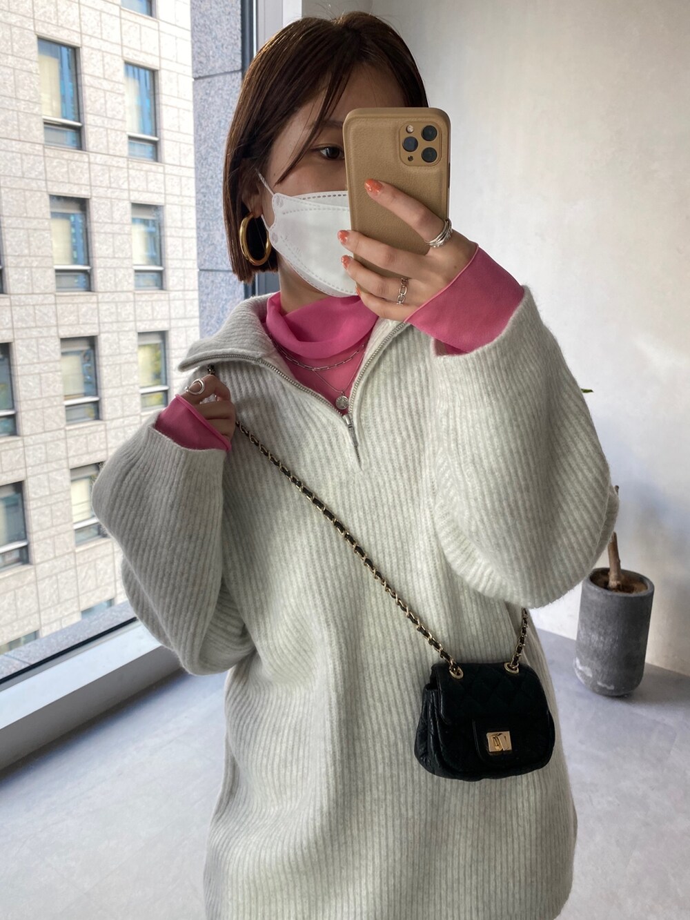 ピンク系のTシャツ/カットソー、グレー系のニット/セーター、グレー系のスカートを着用したレディースの冬コーディネートの3枚目の写真