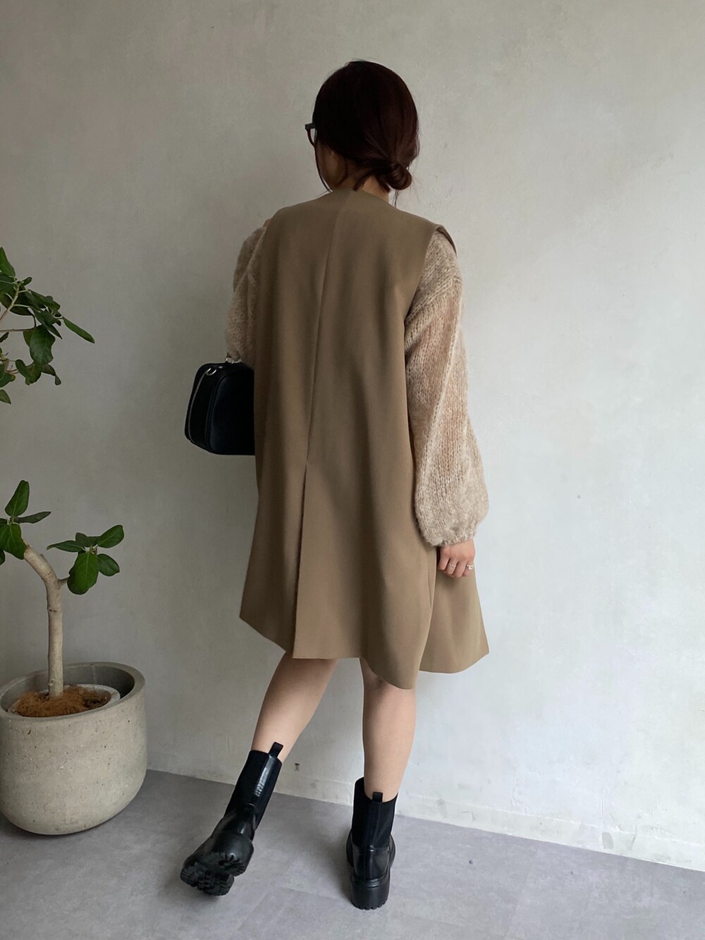 ベージュ系のニット/セーター、イエロー系のベスト、ベージュ系のスカートを着用したレディースの夏コーディネートの4枚目の写真