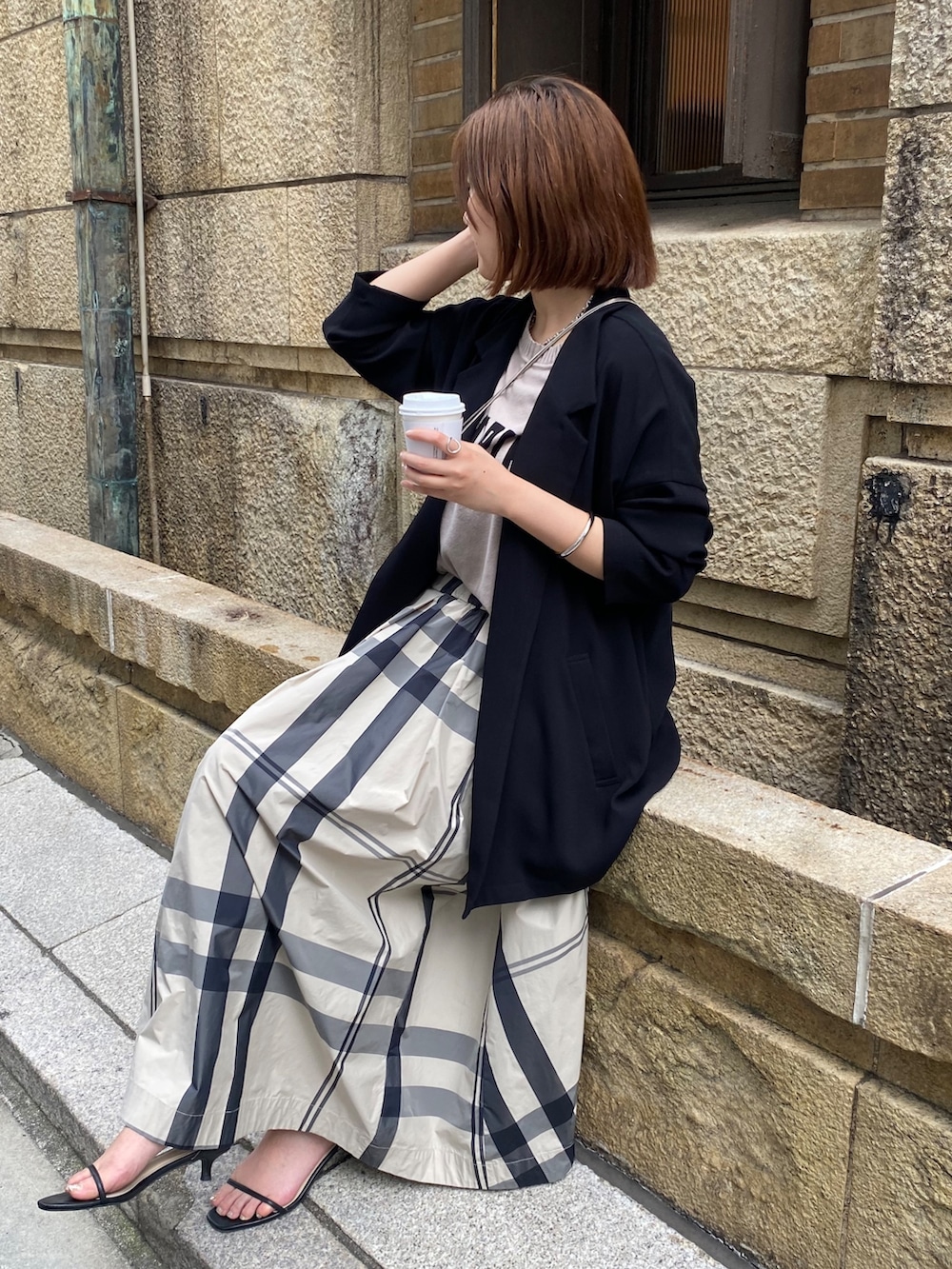 ベージュ系のニット/セーター、ベージュ系のスカート、ブラック系のサンダルを着用したレディースの冬コーディネートの2枚目の写真