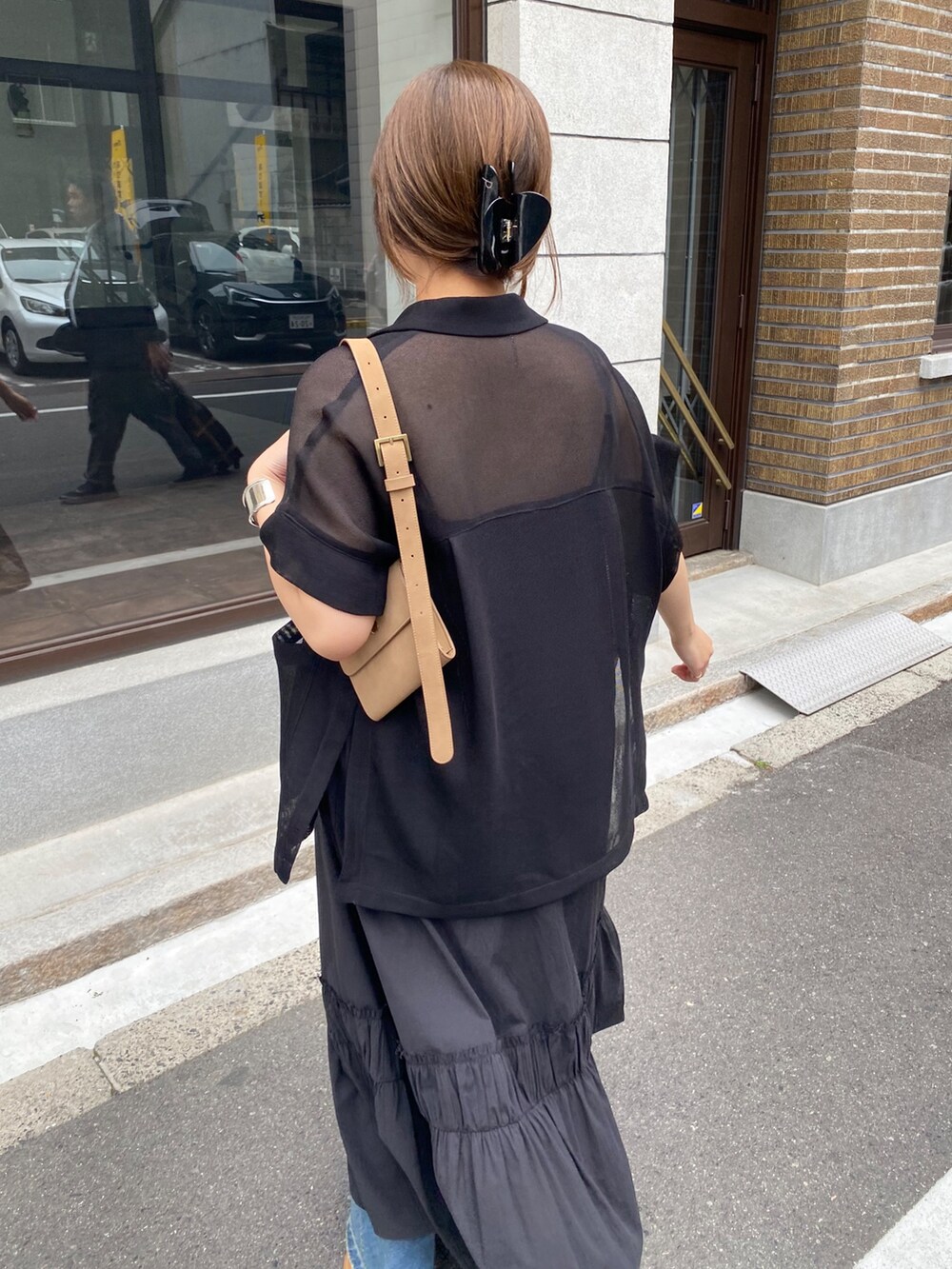 ブラック系のテーラードジャケット、ブラック系のワンピース、ブラック系のネックレスを着用したレディースの春コーディネートの6枚目の写真