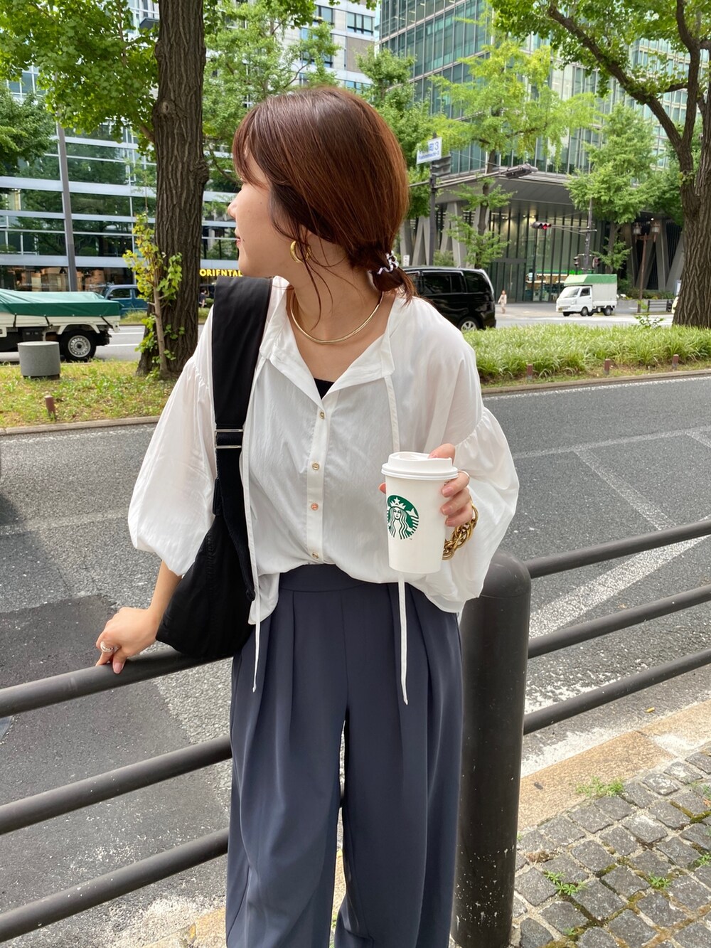 ホワイト系のシャツ/ブラウス、グレー系のスラックス、シルバー系のサンダルを着用したレディースの夏コーディネートの6枚目の写真
