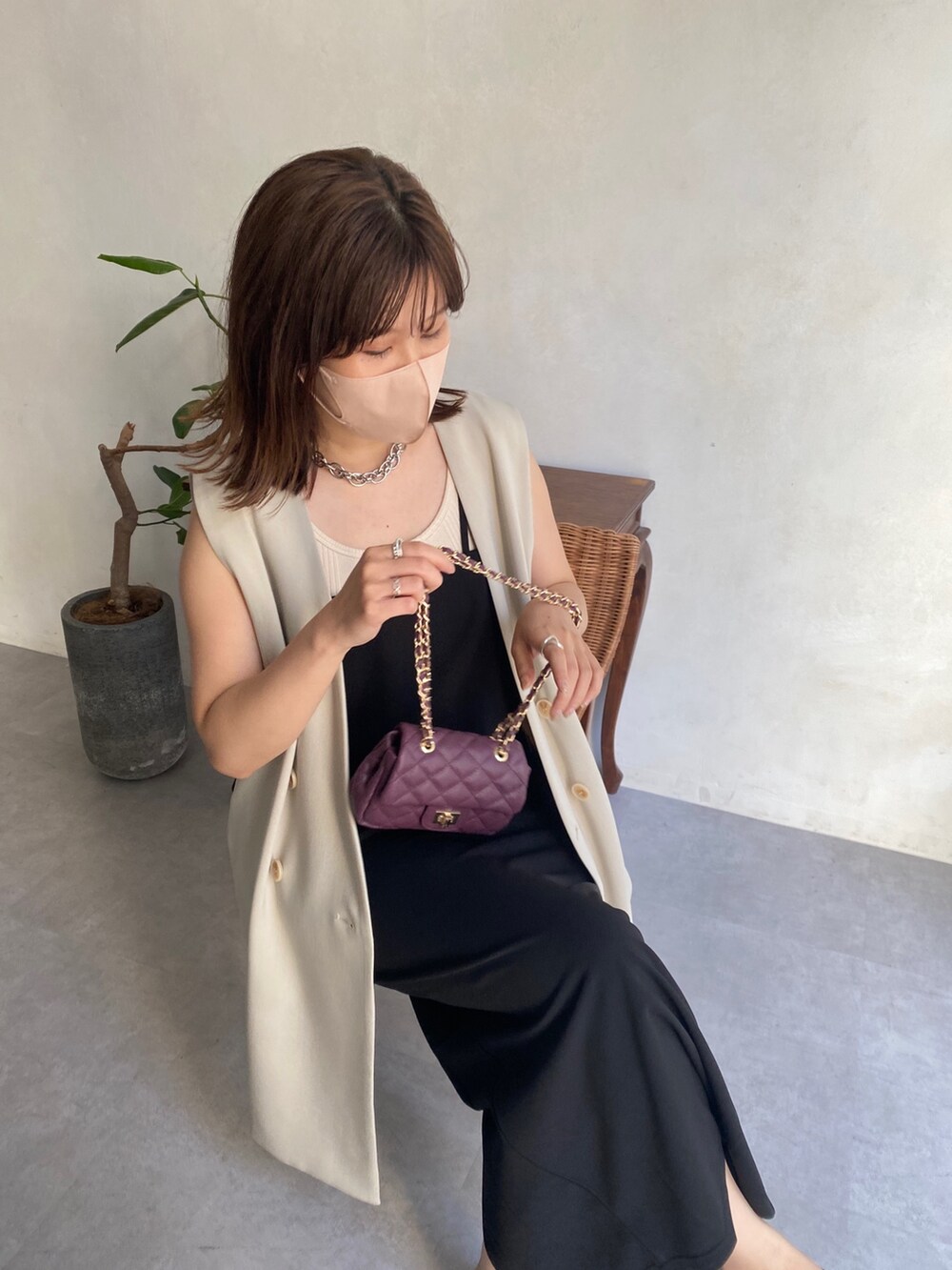 ベージュ系のベスト、ブラック系のワンピース、ブラック系のサンダルを着用したレディースの夏コーディネートの3枚目の写真