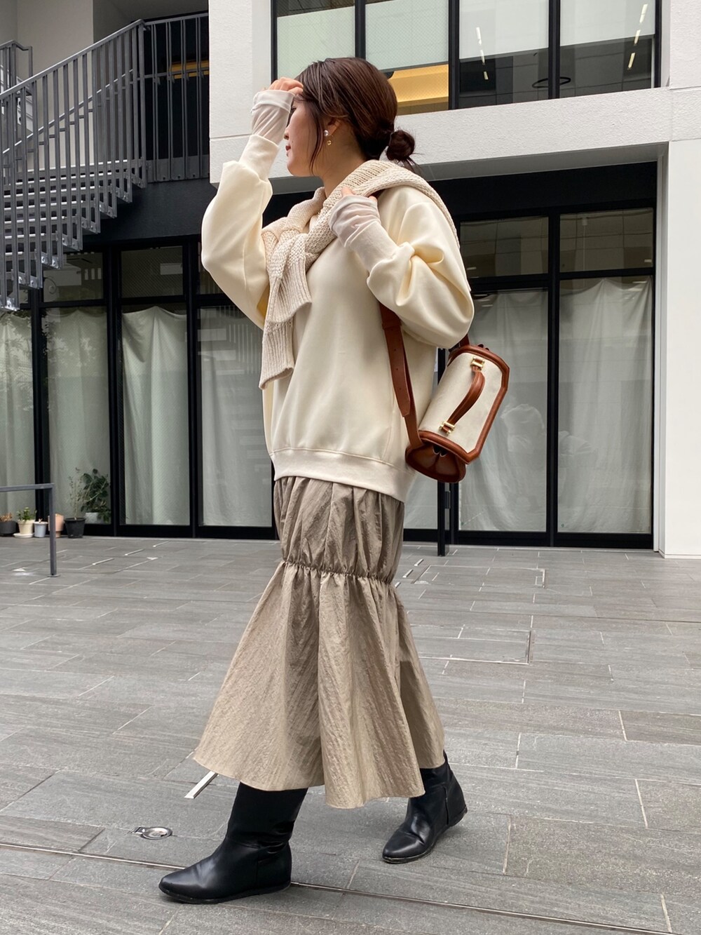 ホワイト系のワンピース、ブラック系のブーツ、シルバー系のネックレスを着用したレディースの冬コーディネートの7枚目の写真