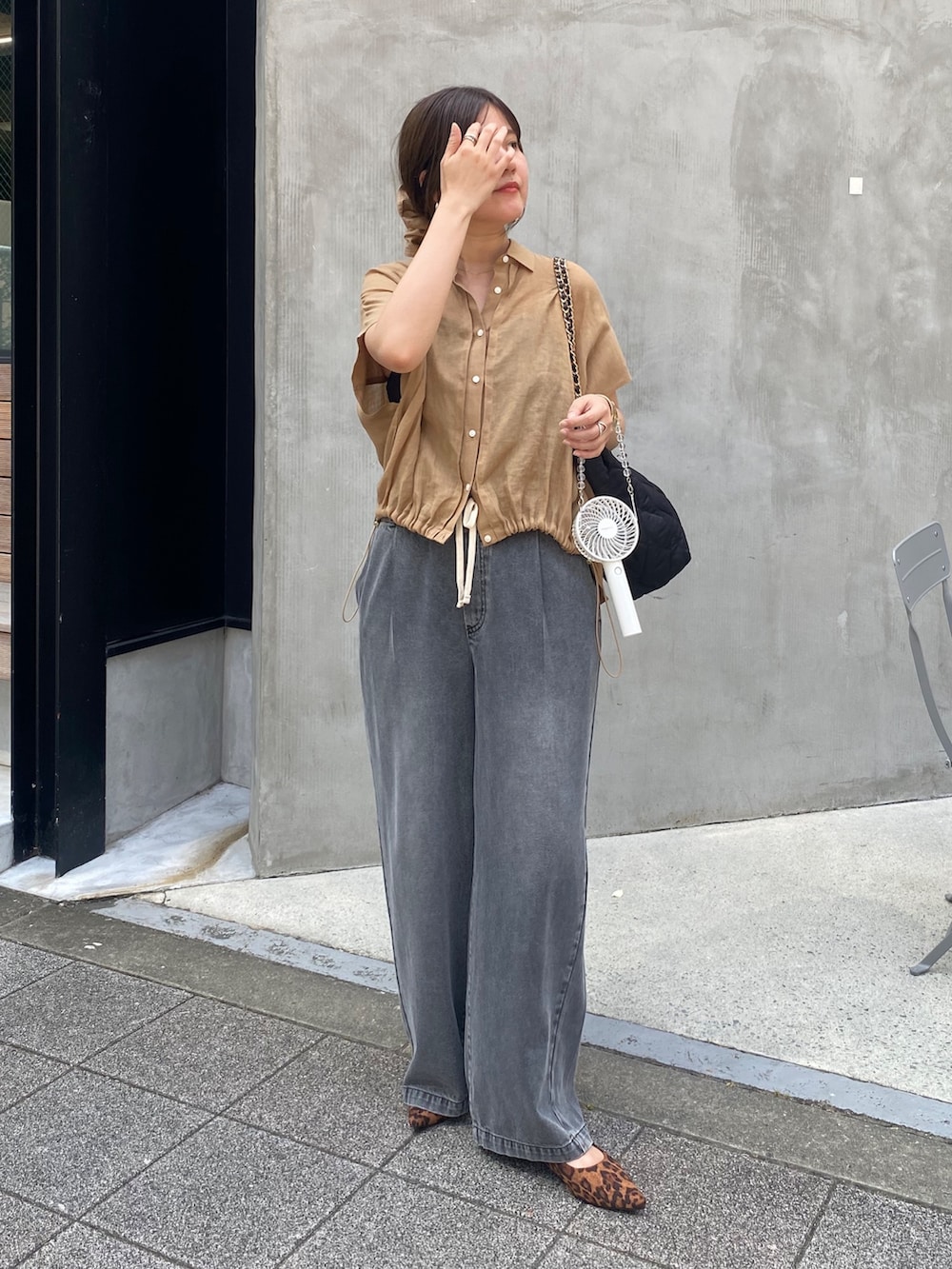 ベージュ系のシャツ/ブラウス、ブラック系のデニムパンツ、ブラウン系のシュシュを着用したレディースの夏コーディネートの3枚目の写真