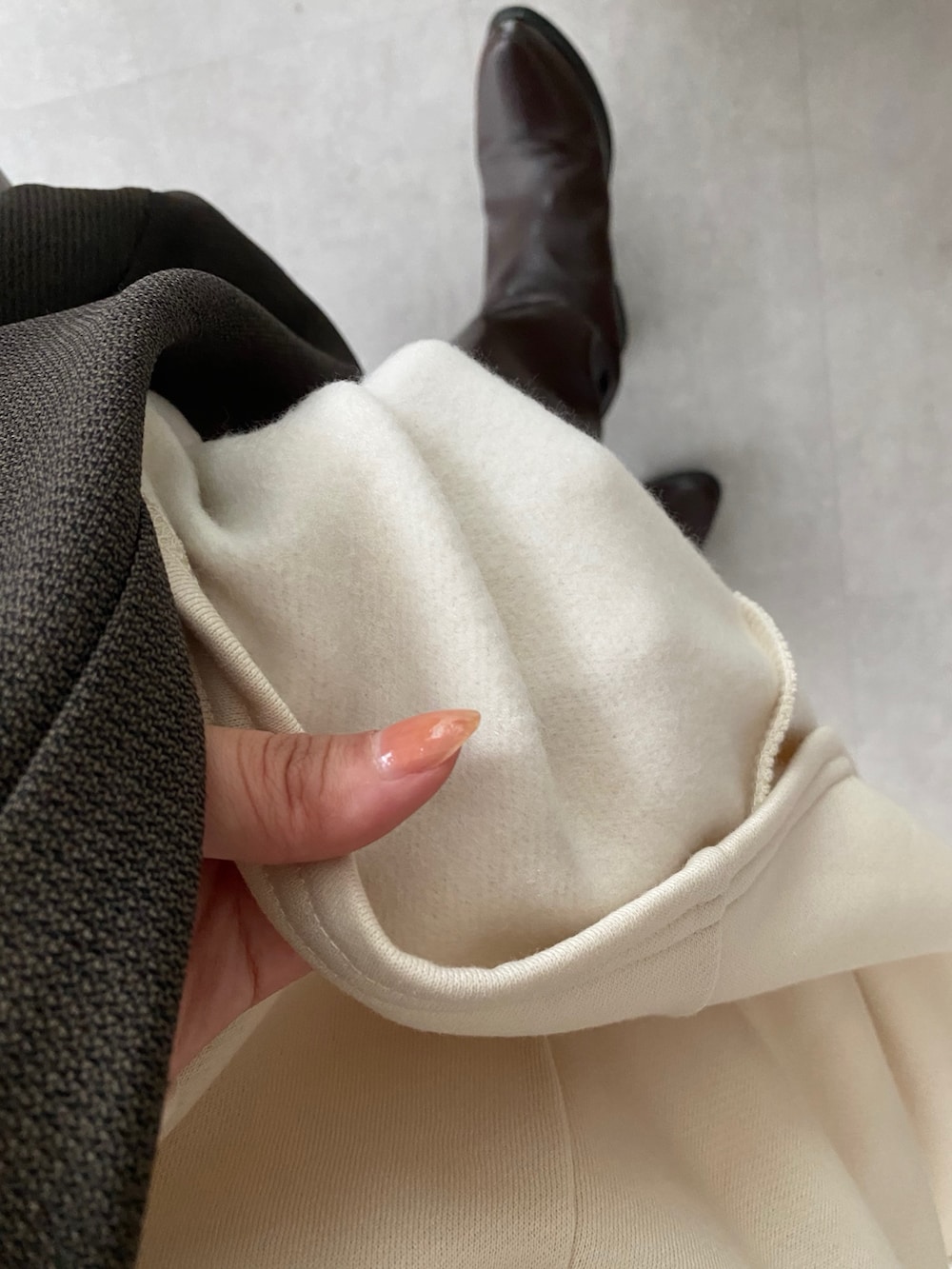 ベージュ系のワンピース、グレー系のテーラードジャケット、グレー系のショルダーバッグを着用したレディースの冬コーディネートの10枚目の写真