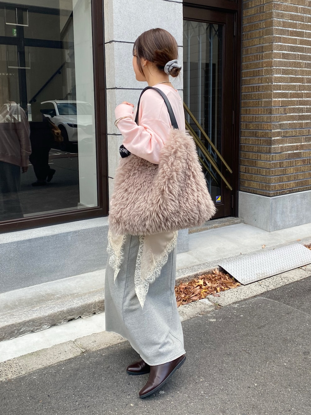 ピンク系のスウェット、ベージュ系のキャミソール、グレー系のスカートを着用したレディースの冬コーディネートの2枚目の写真