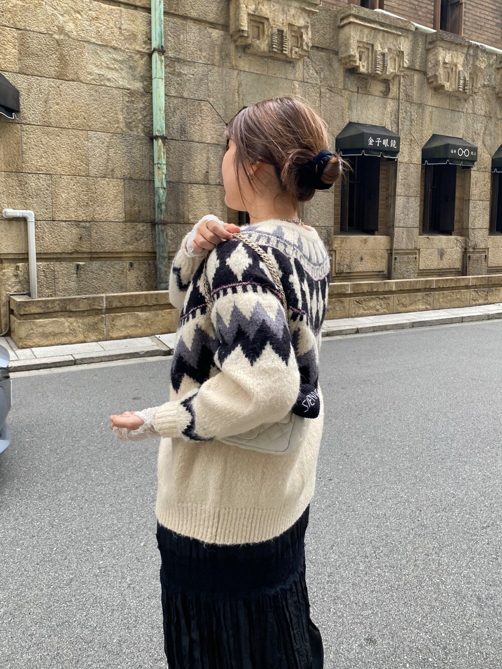ホワイト系のカーディガン/ボレロ、ホワイト系のTシャツ/カットソー、ブラック系のスカートを着用したレディースの冬コーディネートの3枚目の写真