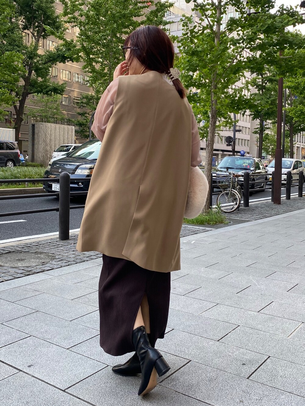 ベージュ系のワンピース、イエロー系のベストを着用したレディースの夏コーディネートの2枚目の写真