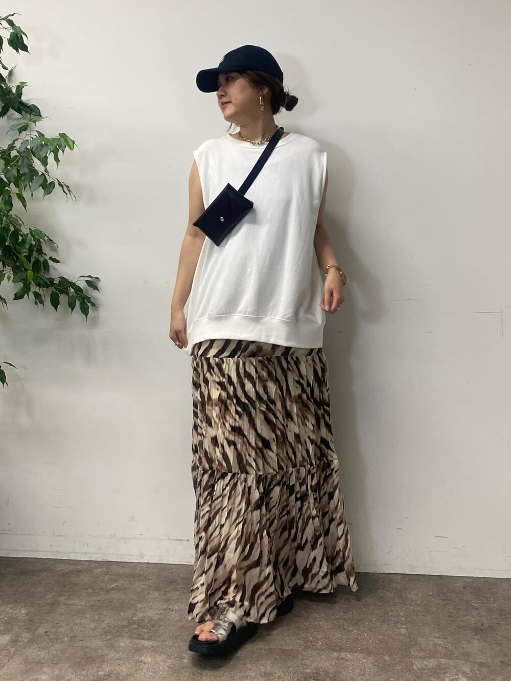 ブラック系のショルダーバッグ、ホワイト系のTシャツ/カットソー、ベージュ系のスカートを着用したレディースの夏コーディネートの6枚目の写真