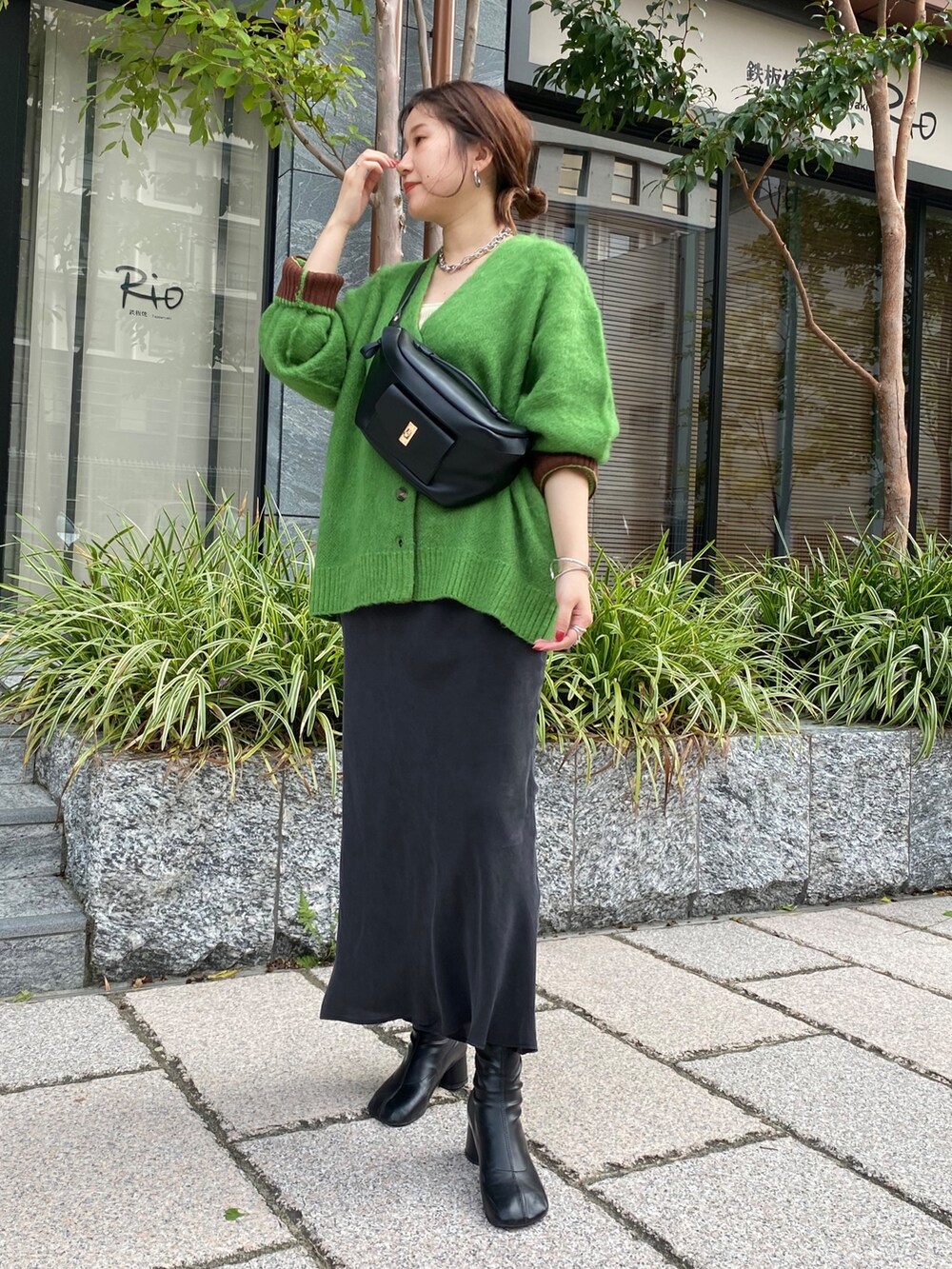 グリーン系のカーディガン/ボレロ、ブラック系のスカート、ブラック系のその他シューズを着用したレディースの秋コーディネートの5枚目の写真
