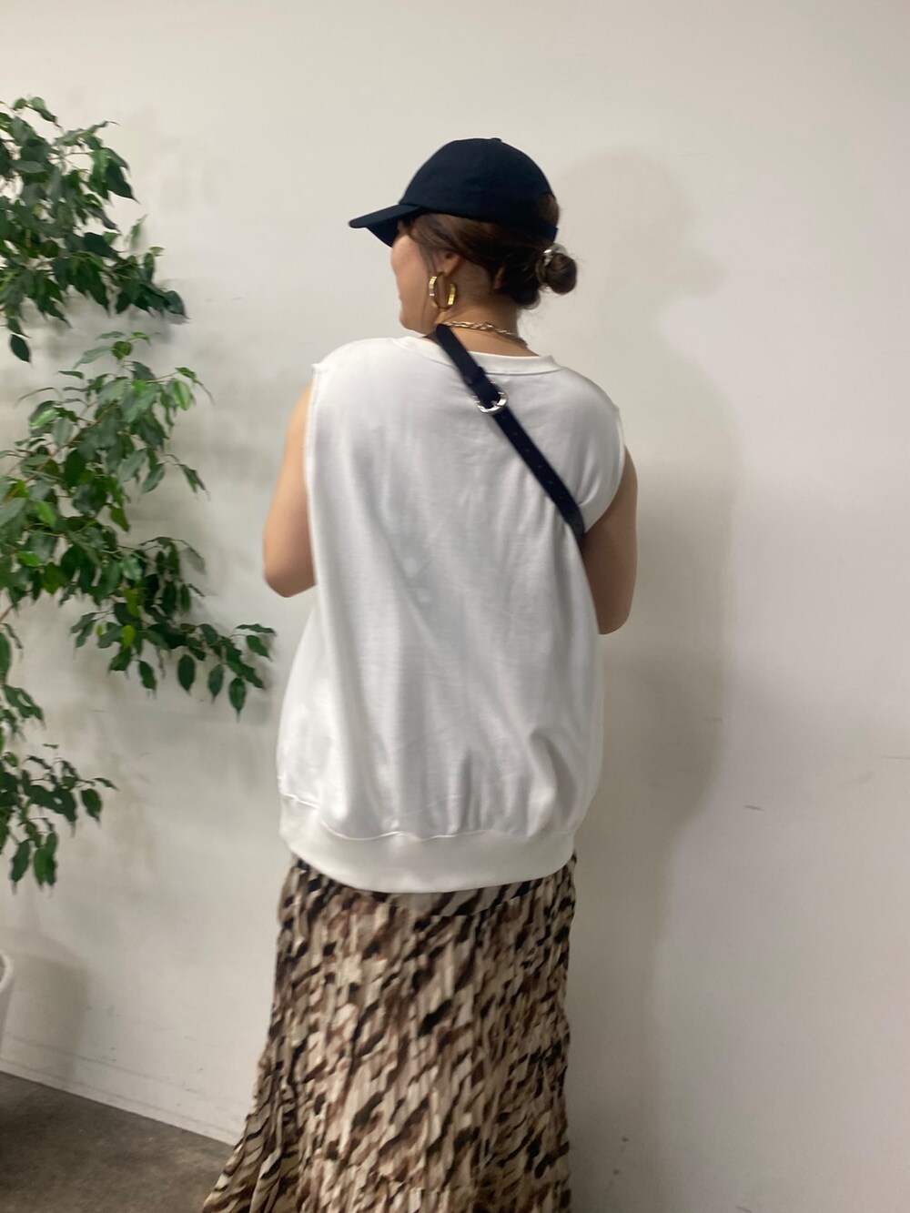 ブラック系のショルダーバッグ、ホワイト系のTシャツ/カットソー、ベージュ系のスカートを着用したレディースの夏コーディネートの4枚目の写真