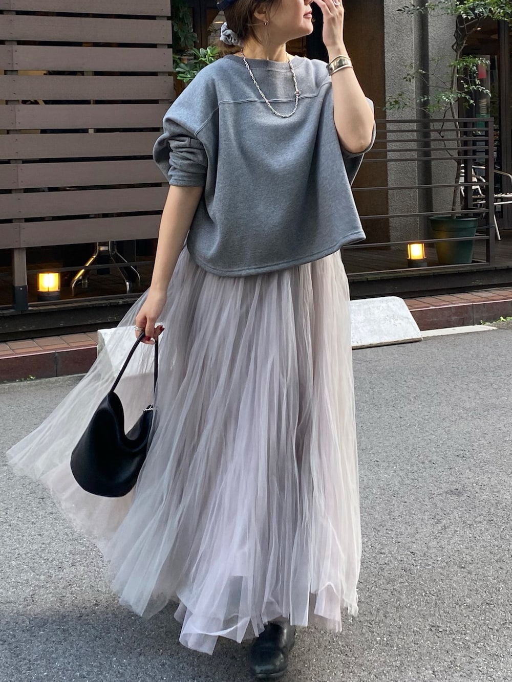 グレー系のムートンコート、グレー系のTシャツ/カットソー、グレー系のスカートを着用したレディースの冬コーディネートの2枚目の写真