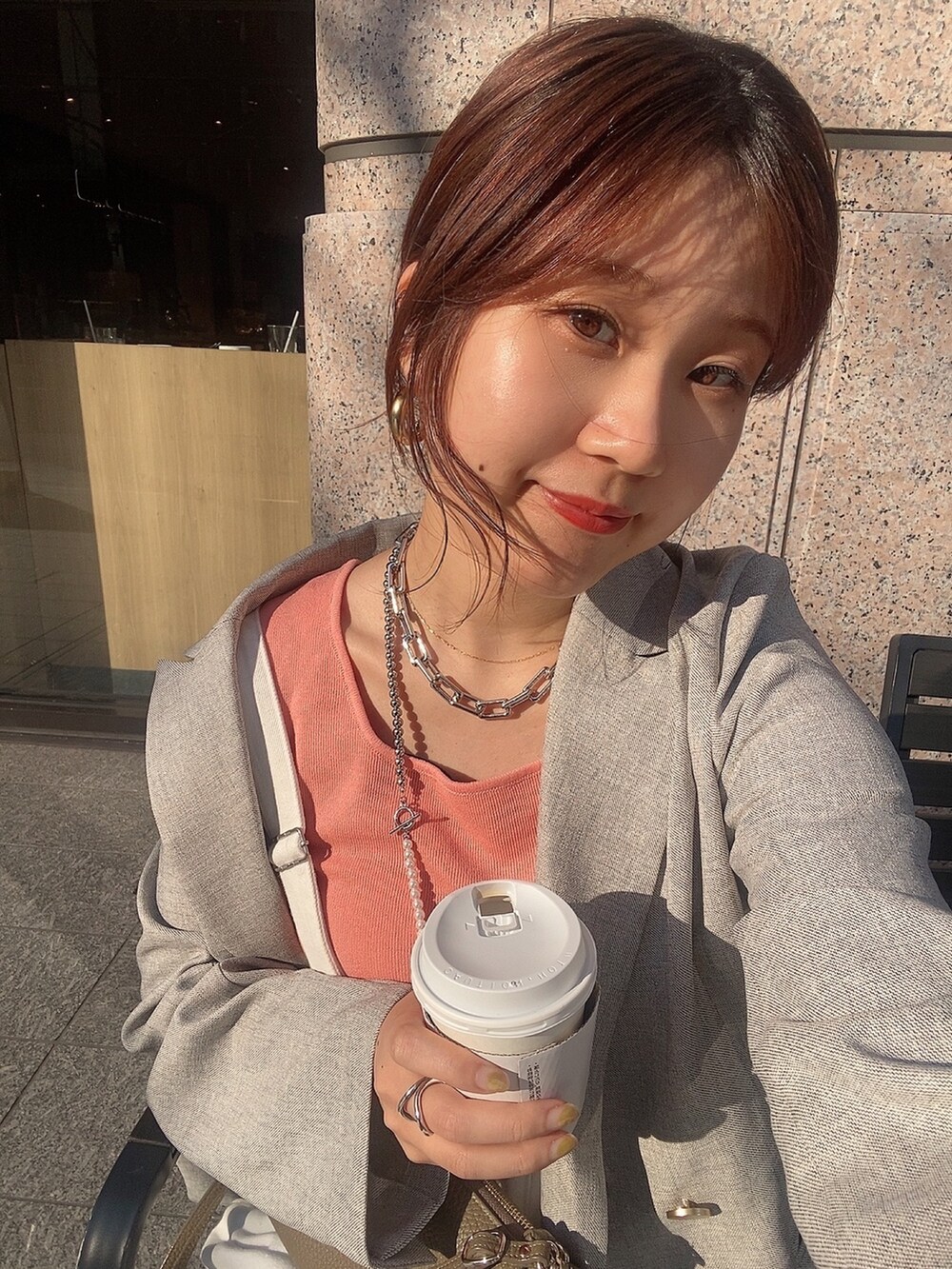 ピンク系のタンクトップ、ホワイト系のサロペット/オーバーオール、グレー系のテーラードジャケットを着用したレディースの春コーディネートの3枚目の写真