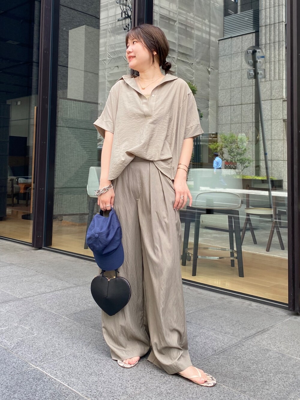 ベージュ系のシャツ/ブラウス、ブラック系のショルダーバッグ、ベージュ系のTシャツ/カットソーを着用したレディースの夏コーディネートの7枚目の写真