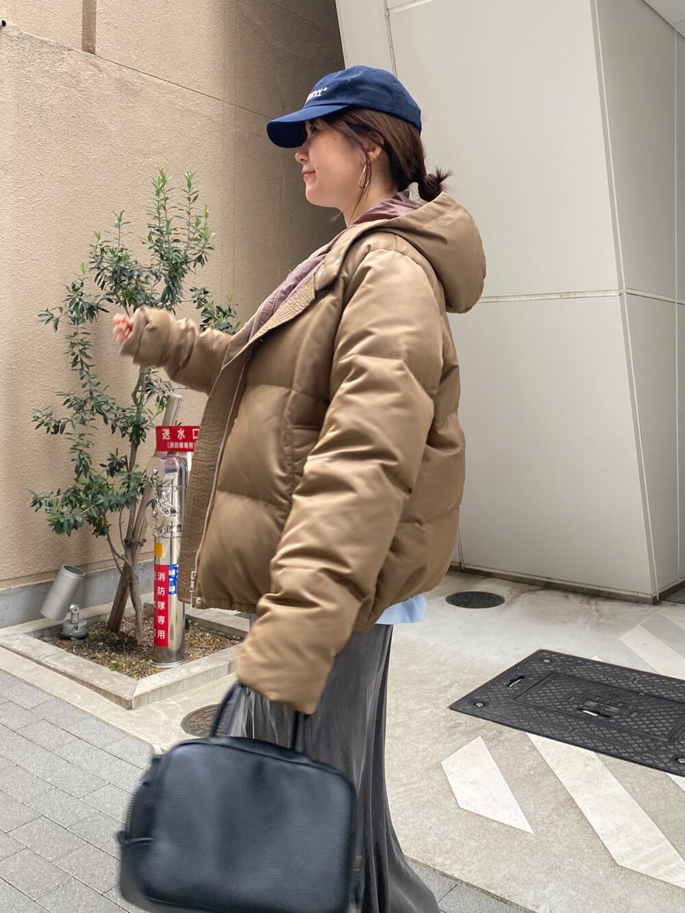 ブルー系のTシャツ/カットソー、ブラック系のスカート、ブラック系のショルダーバッグを着用したレディースの春コーディネートの6枚目の写真