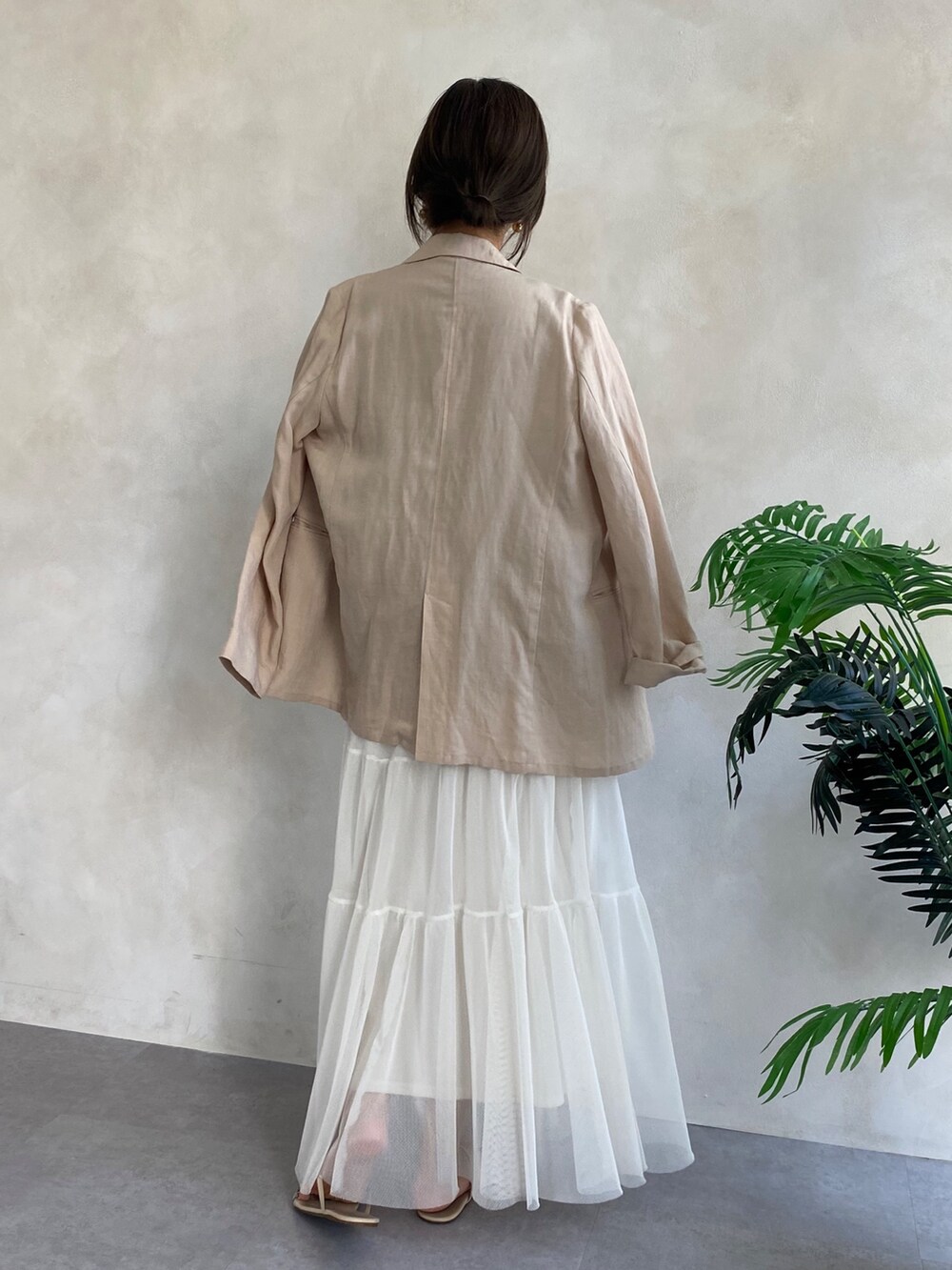 ベージュ系のテーラードジャケット、ホワイト系のスカート、ブラウン系のショルダーバッグを着用したレディースの夏コーディネートの6枚目の写真