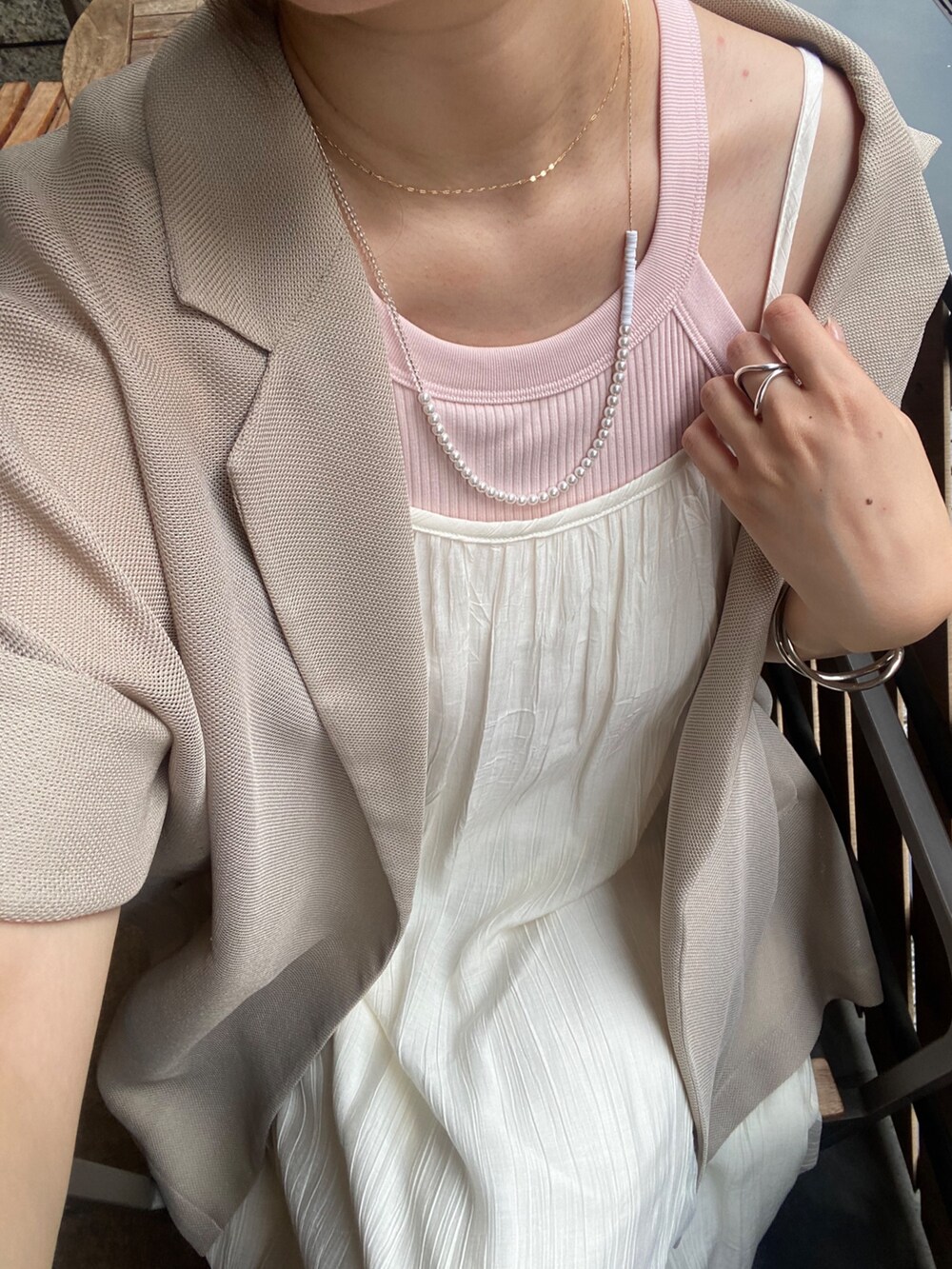 ホワイト系のワンピース、ベージュ系のテーラードジャケット、ホワイト系のキャップを着用したレディースの夏コーディネートの4枚目の写真