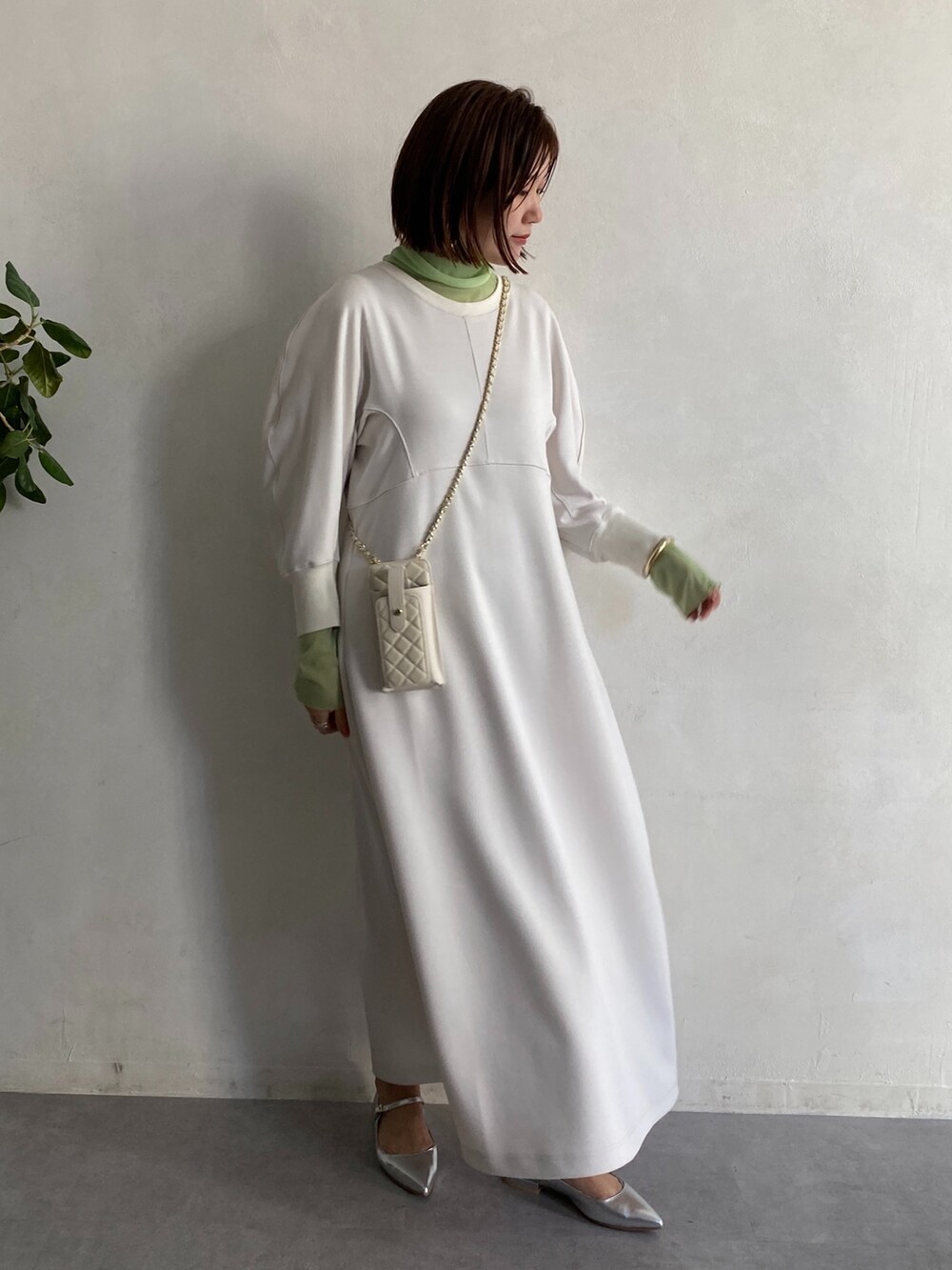 グリーン系のTシャツ/カットソー、ホワイト系のショルダーバッグ、ホワイト系のワンピースを着用したレディースの冬コーディネートの7枚目の写真