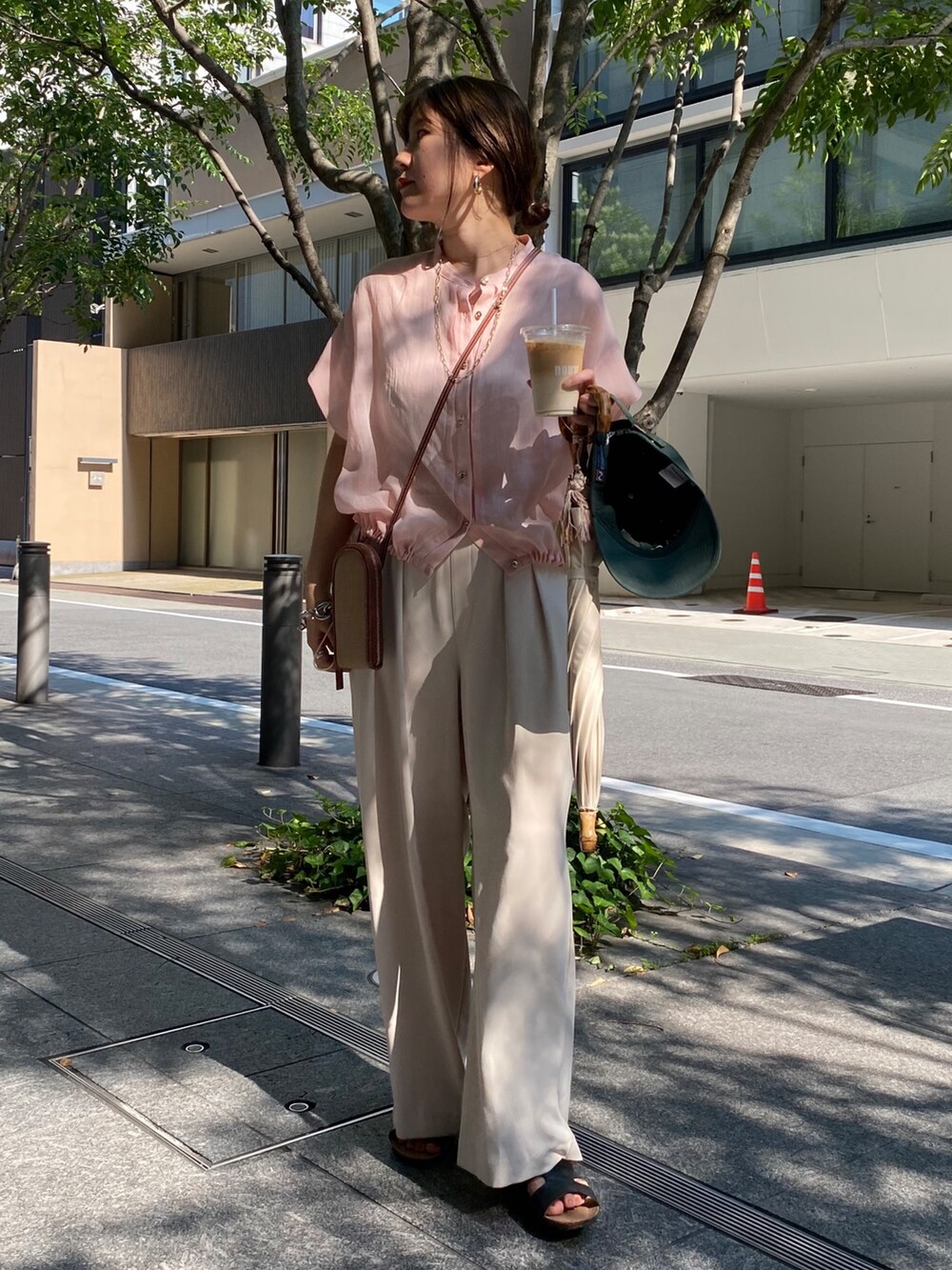 ピンク系のシャツ/ブラウス、ホワイト系のスラックス、ゴールド系のネックレスを着用したレディースの夏コーディネートの3枚目の写真