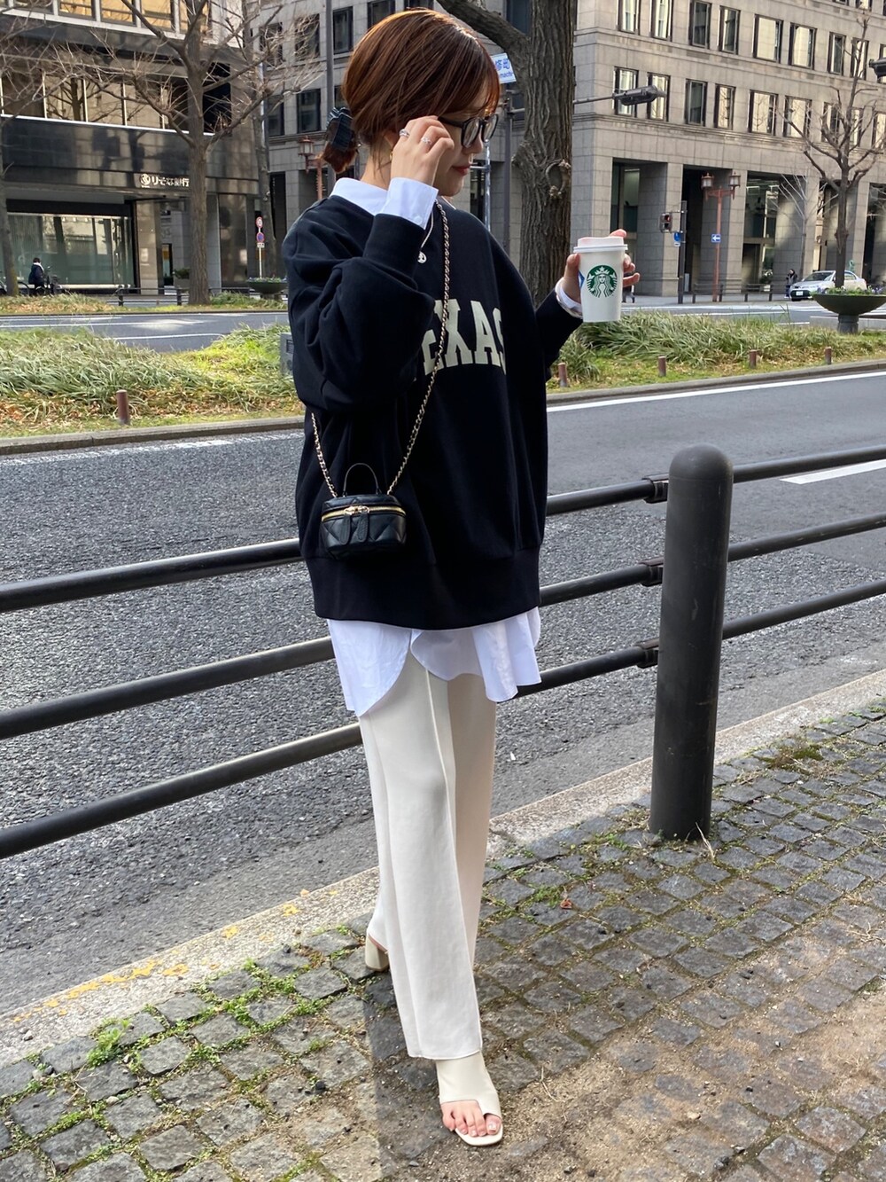 ブラック系のスウェット、ホワイト系のシャツ/ブラウス、ホワイト系のスラックスを着用したレディースの春コーディネートの6枚目の写真
