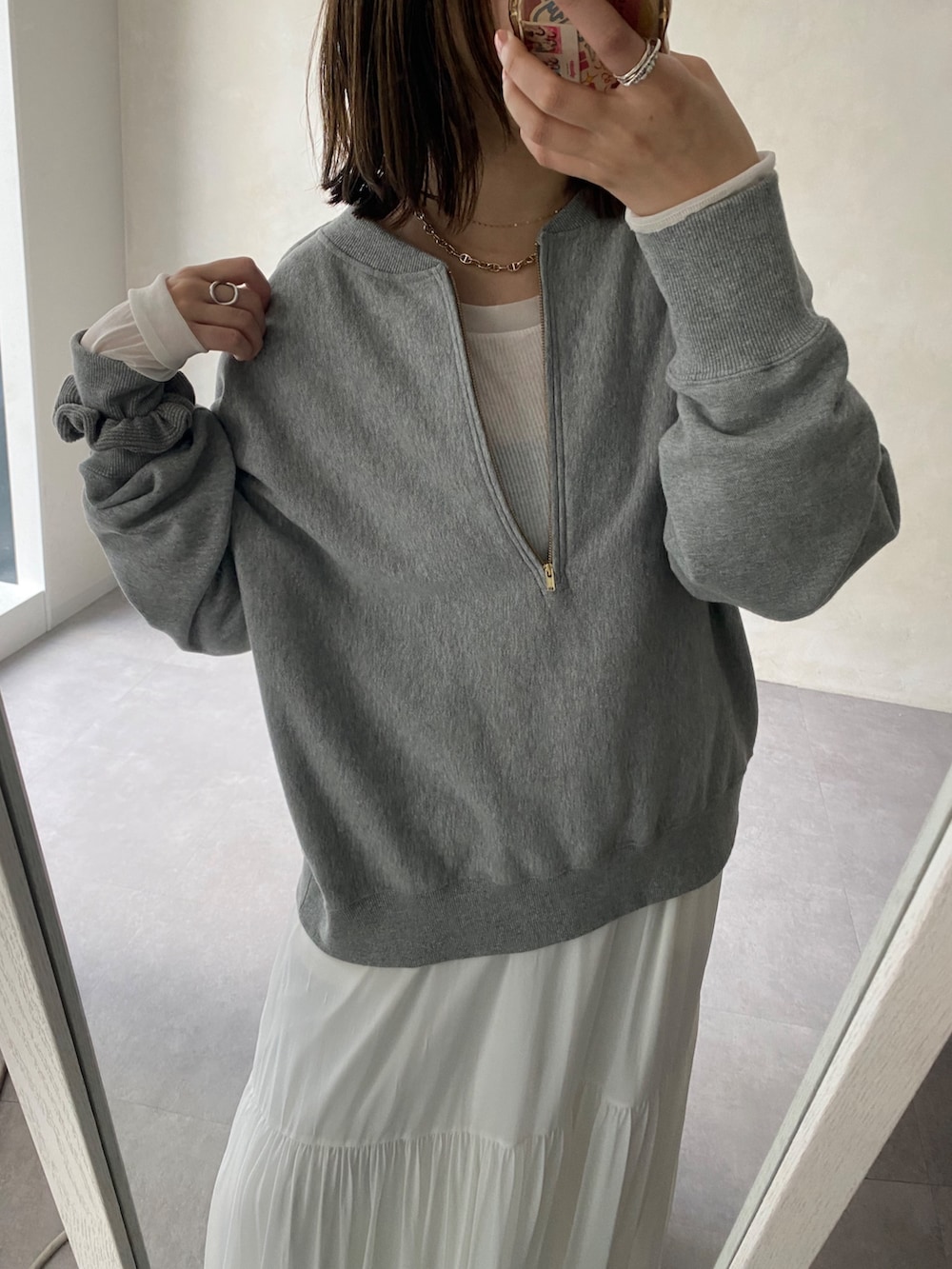 グレー系のスウェット、ブルー系のシャツ/ブラウス、ホワイト系のスカートを着用したレディースの冬コーディネートの2枚目の写真