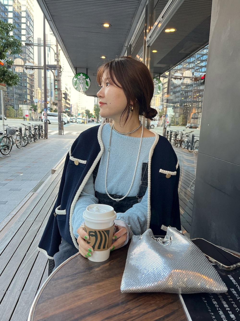 ブルー系のノーカラージャケット、ブラック系のサロペット/オーバーオール、ゴールド系のショルダーバッグを着用したレディースの冬コーディネートの2枚目の写真