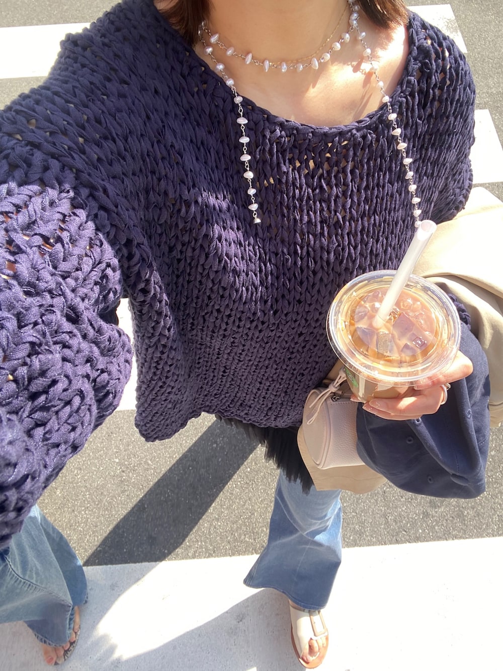 ブルー系のニット/セーター、ブラック系のシャツ/ブラウス、ブルー系のデニムパンツを着用したレディースの春コーディネートの4枚目の写真