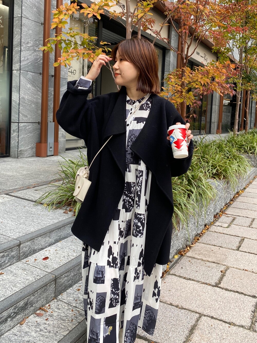 ホワイト系のワンピース、ホワイト系のトートバッグ、ホワイト系のブーツを着用したレディースの秋コーディネートの4枚目の写真