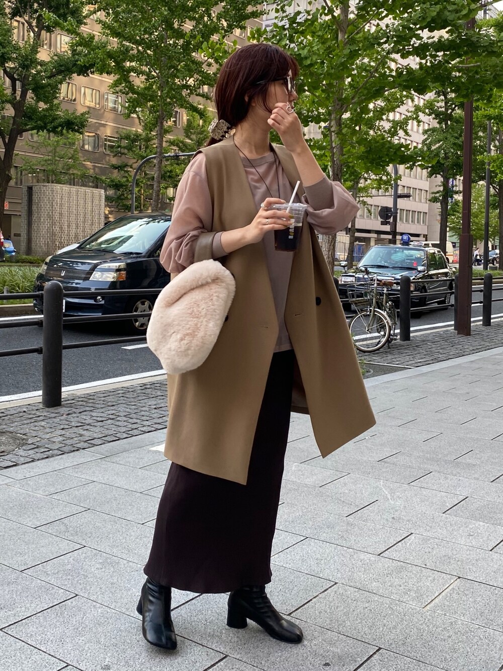 ベージュ系のワンピース、イエロー系のベストを着用したレディースの夏コーディネートの4枚目の写真