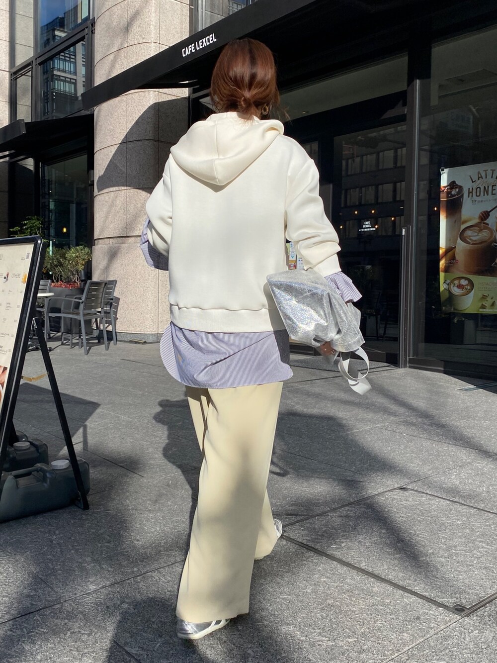 ホワイト系のパーカー、ブラック系のシャツ/ブラウス、イエロー系のスラックスを着用したレディースの冬コーディネートの4枚目の写真