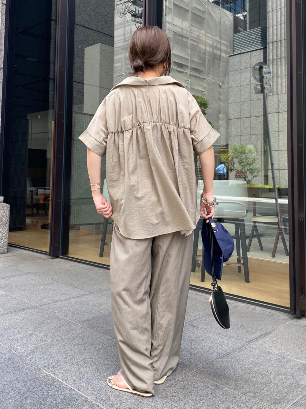 ベージュ系のシャツ/ブラウス、ブラック系のショルダーバッグ、ベージュ系のTシャツ/カットソーを着用したレディースの夏コーディネートの8枚目の写真