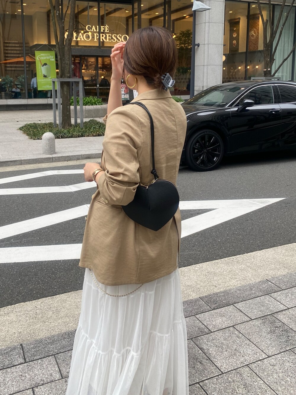 イエロー系のテーラードジャケット、ホワイト系のTシャツ/カットソー、ホワイト系のスカートを着用したレディースの春コーディネートの7枚目の写真