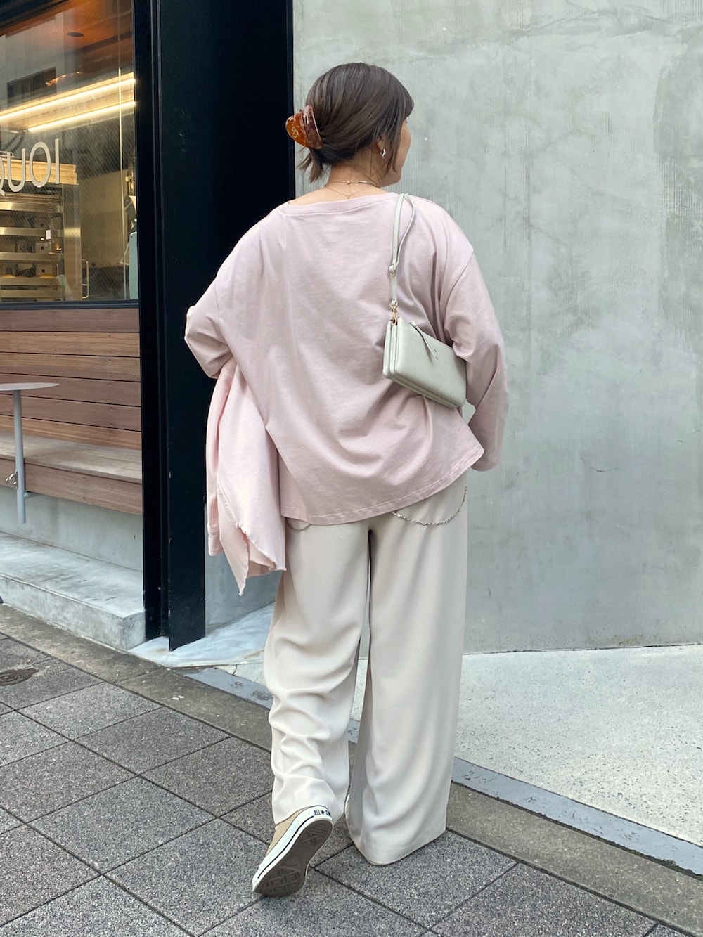 ピンク系のシャツ/ブラウス、ピンク系のTシャツ/カットソー、グレー系のスラックスを着用したレディースの冬コーディネートの7枚目の写真