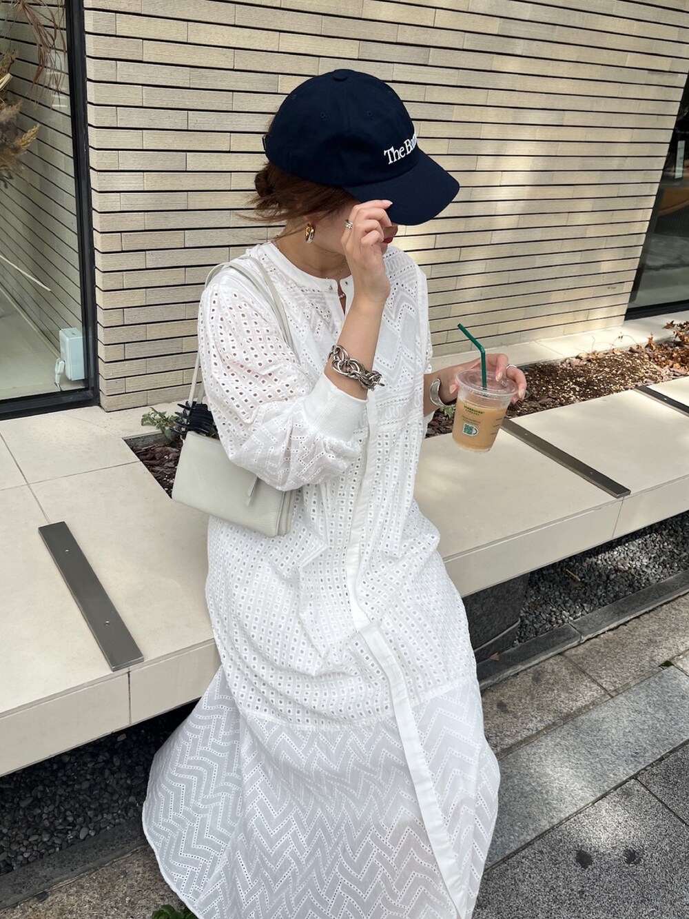 ホワイト系のワンピース、ホワイト系のショルダーバッグ、ゴールド系のブレスレットを着用したレディースの夏コーディネートの4枚目の写真