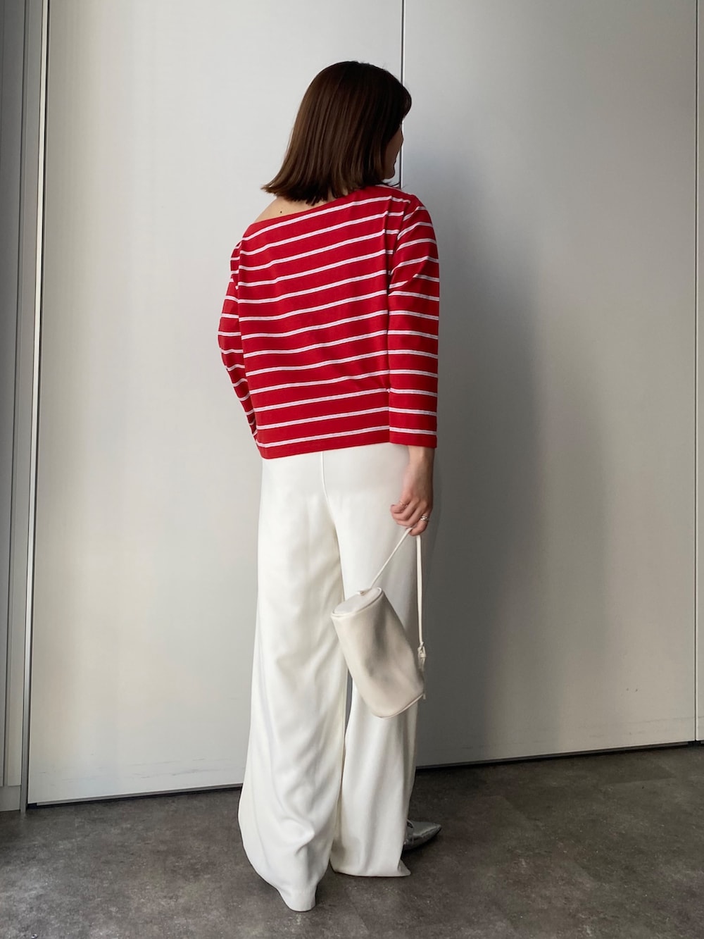 レッド系のTシャツ/カットソー、ホワイト系のスラックスを着用したレディースの春コーディネートの5枚目の写真