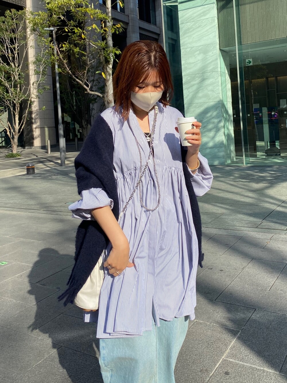 ブルー系のシャツ/ブラウス、ブルー系のデニムパンツ、シルバー系のサンダルを着用したレディースの冬コーディネートの3枚目の写真