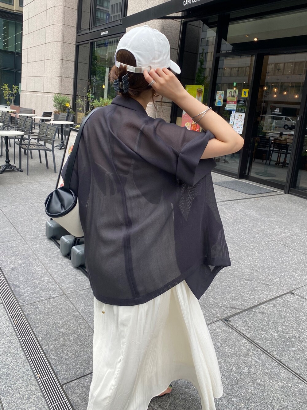 グレー系のテーラードジャケット、ホワイト系のワンピース、ホワイト系のキャップを着用したレディースの夏コーディネートの6枚目の写真