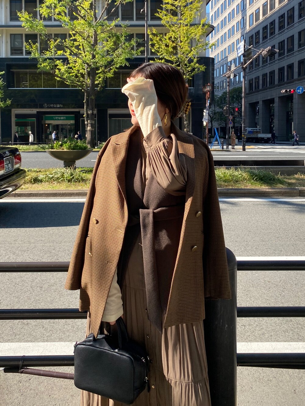 ブラウン系のベスト、ブラウン系のテーラードジャケット、ブラウン系のワンピースを着用したレディースの冬コーディネートの9枚目の写真