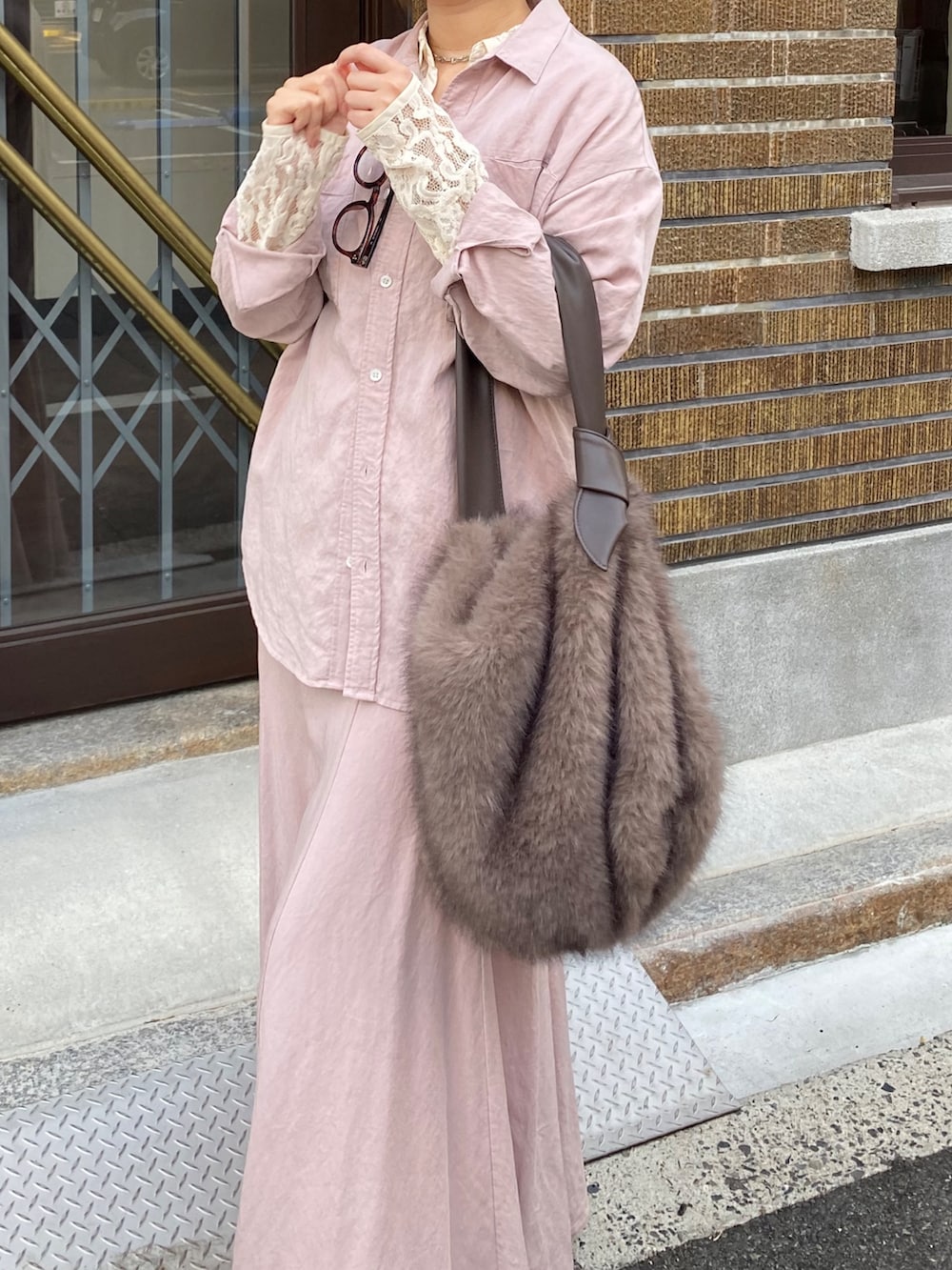 ピンク系のシャツ/ブラウス、ピンク系のスカート、ブラウン系のショルダーバッグを着用したレディースの冬コーディネートの4枚目の写真