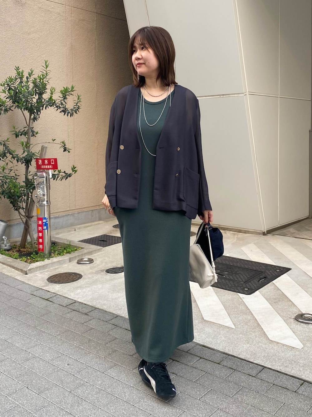 グレー系のテーラードジャケット、グリーン系のワンピースを着用したレディースの春コーディネートの9枚目の写真