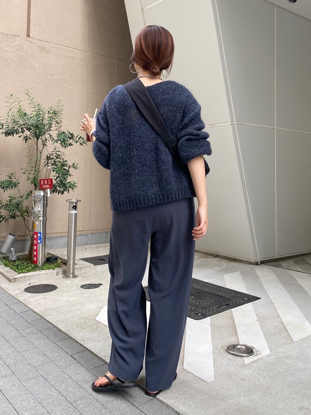グレー系のニット/セーター、グレー系のスラックス、ブラック系のショルダーバッグを着用したレディースの秋コーディネートの3枚目の写真
