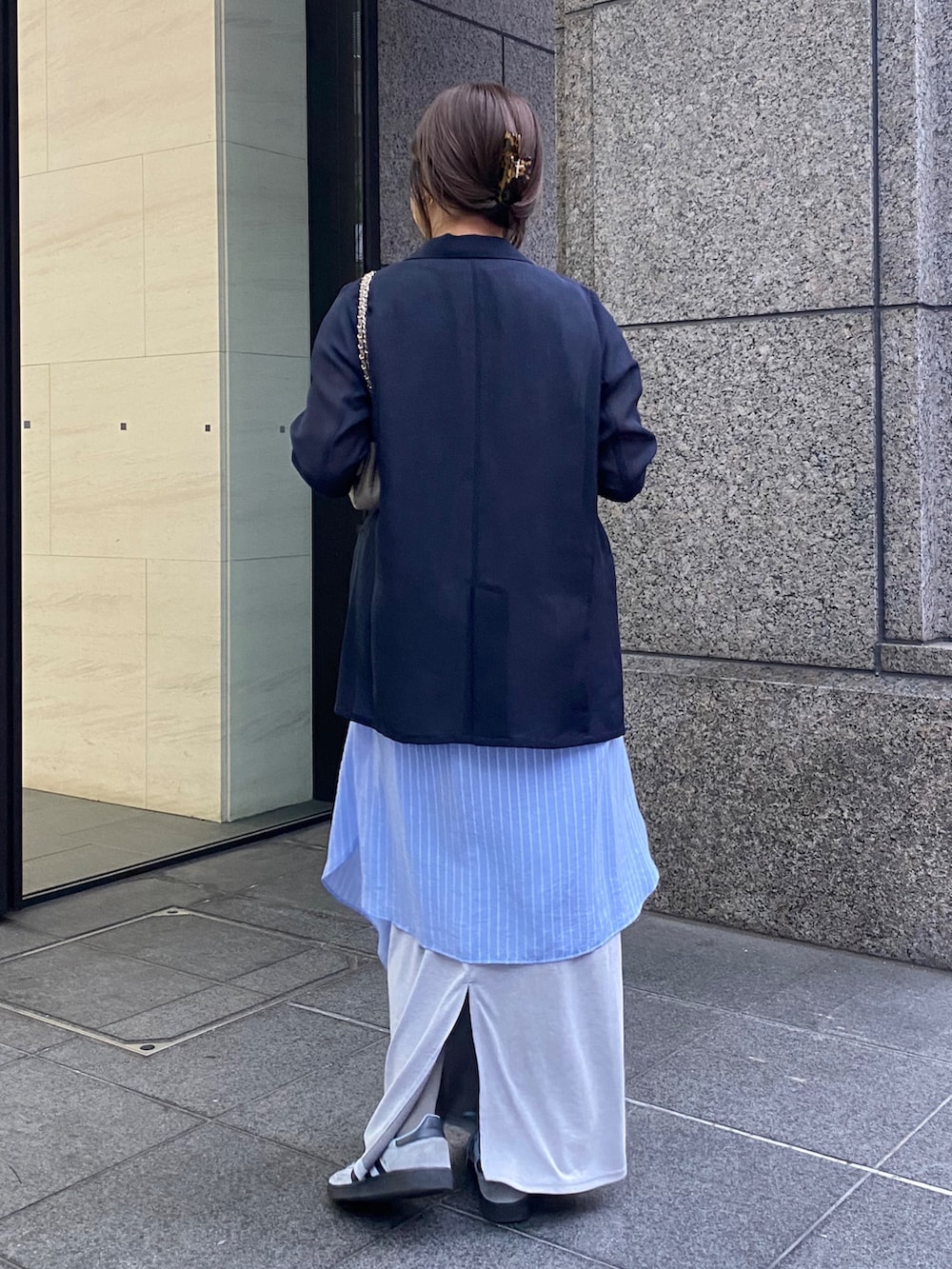 ブルー系のテーラードジャケット、グレー系のTシャツ/カットソー、グレー系のスカートを着用したレディースの春コーディネートの4枚目の写真