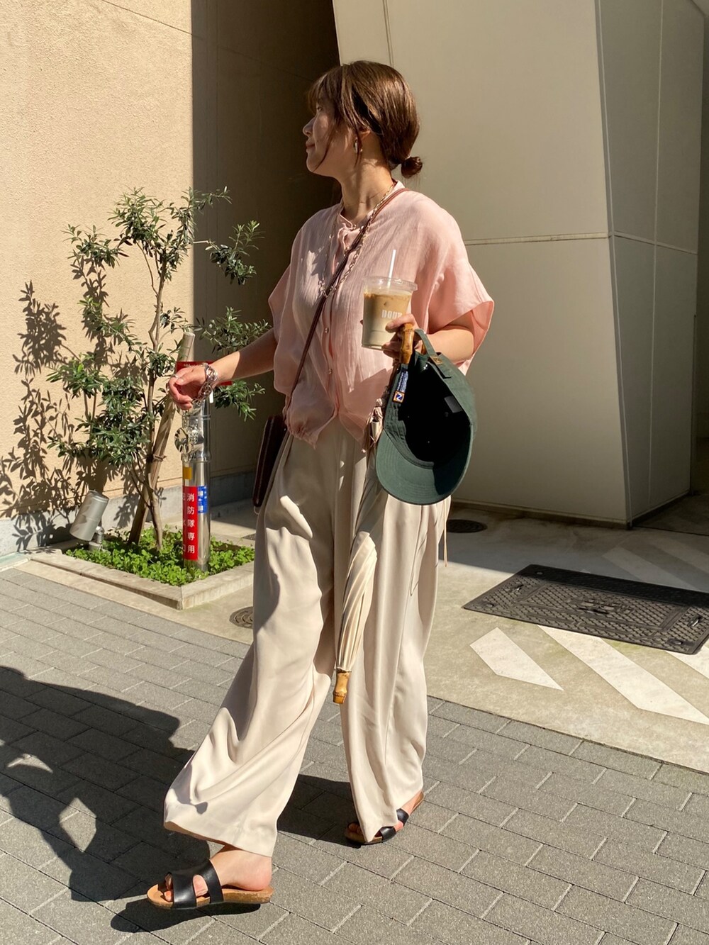 ピンク系のシャツ/ブラウス、ホワイト系のスラックス、ゴールド系のネックレスを着用したレディースの夏コーディネートの7枚目の写真