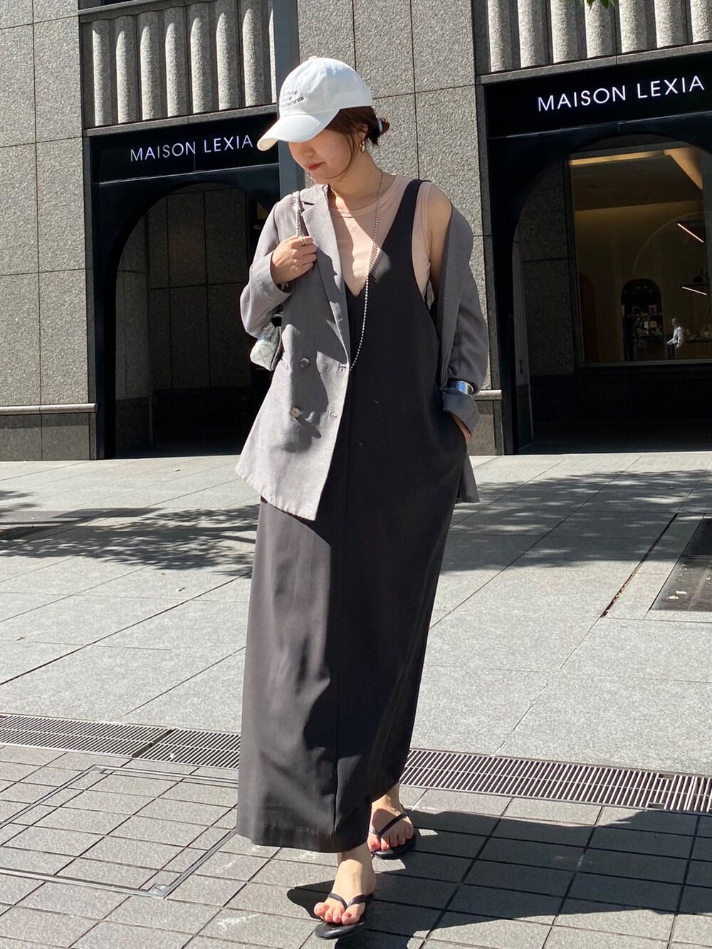 グレー系のワンピース、グレー系のテーラードジャケット、シルバー系のネックレスを着用したレディースの秋コーディネートの6枚目の写真
