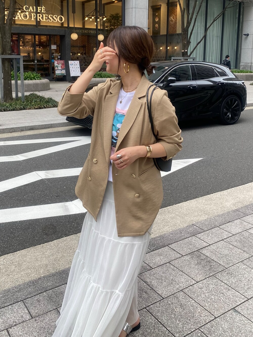 イエロー系のテーラードジャケット、ホワイト系のTシャツ/カットソー、ホワイト系のスカートを着用したレディースの春コーディネートの5枚目の写真