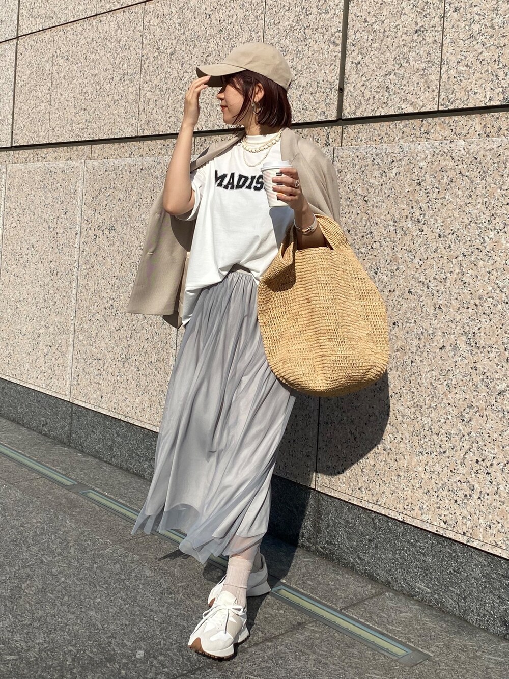ホワイト系のTシャツ/カットソー、ベージュ系のテーラードジャケット、グレー系のスカートを着用したレディースの春コーディネートの3枚目の写真