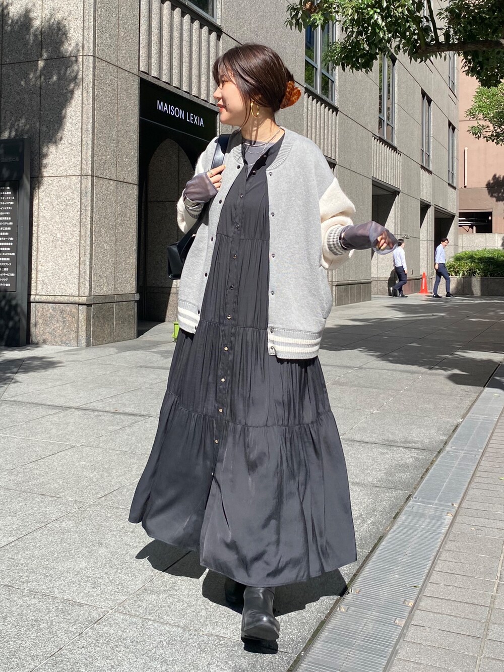 グレー系のその他アウター、ブラック系のワンピース、ブラック系のブーツを着用したレディースの秋コーディネートの2枚目の写真