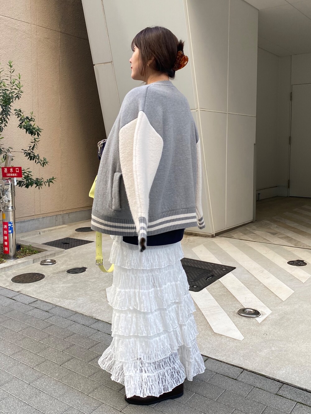 グレー系のその他アウター、ブルー系のTシャツ/カットソー、ホワイト系のスカートを着用したレディースの冬コーディネートの3枚目の写真